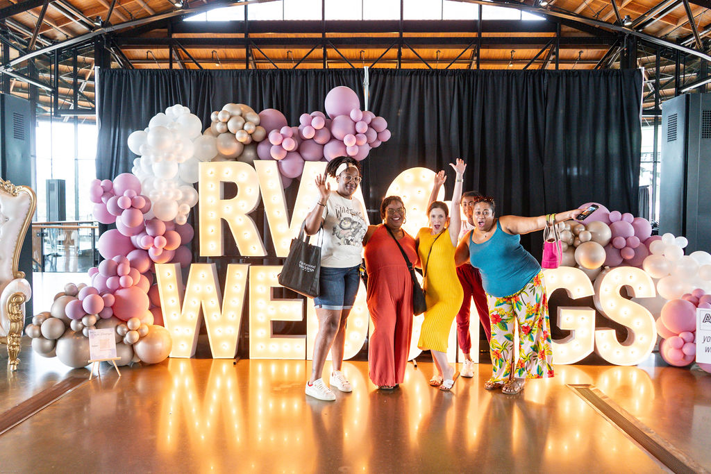 Group posing in front of marquee letters