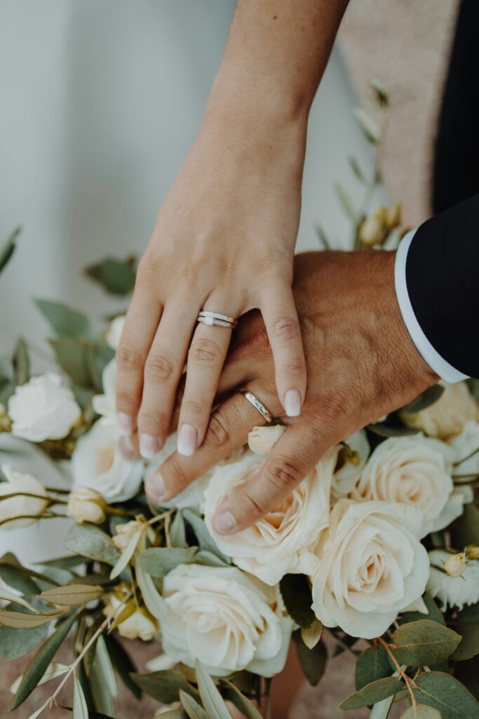 Wedding couple hands on a floral bouquet