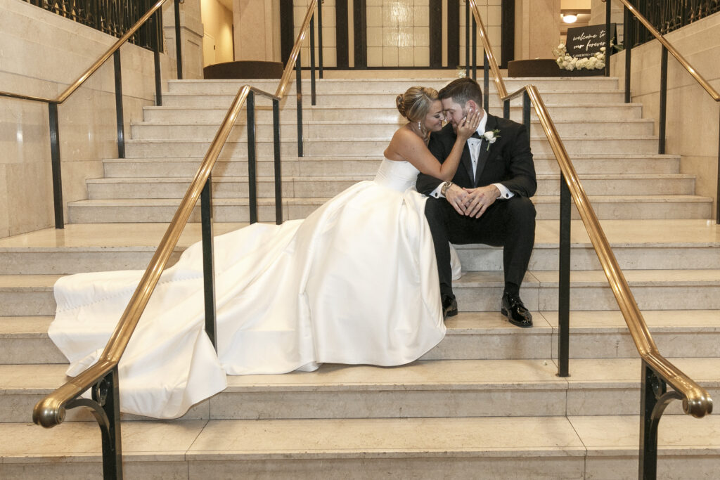 bride and groom on the stairs at the john marshall hotel in richmond va