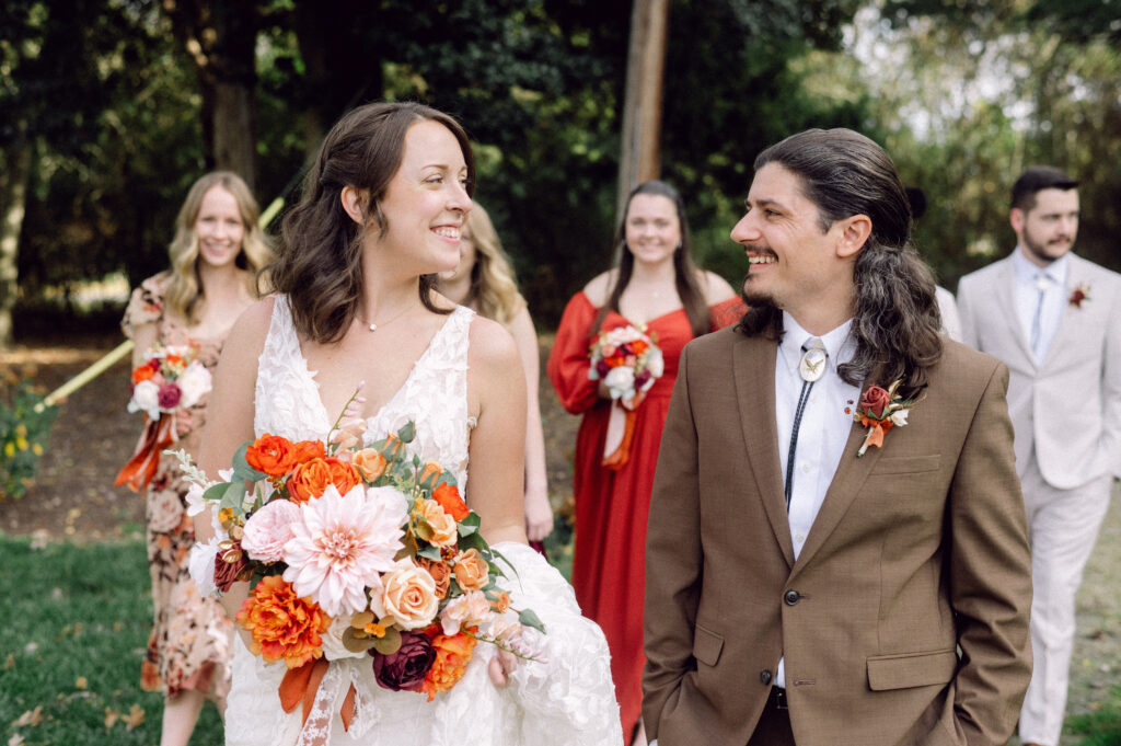 bride and groom walking down the aisle with fall floral bouquet