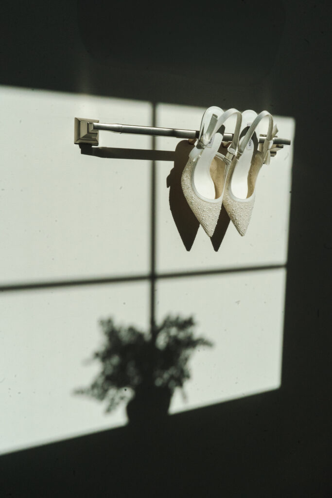 white wedding shoes against wall