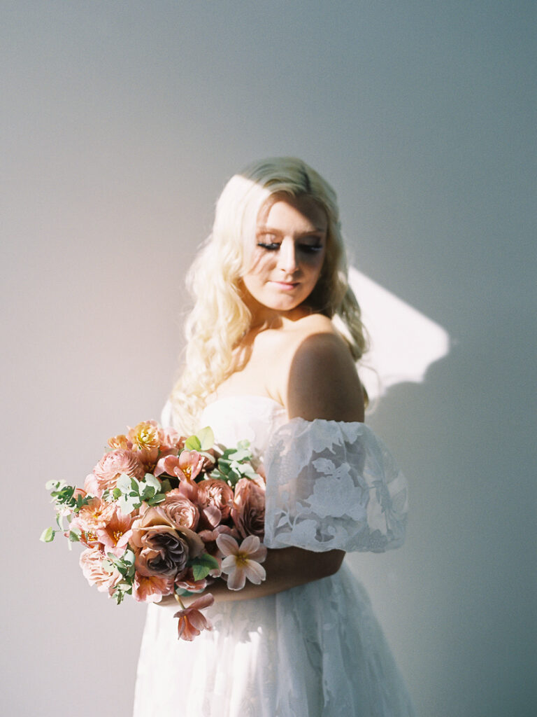 Bride looking over shoulder holding bouquet