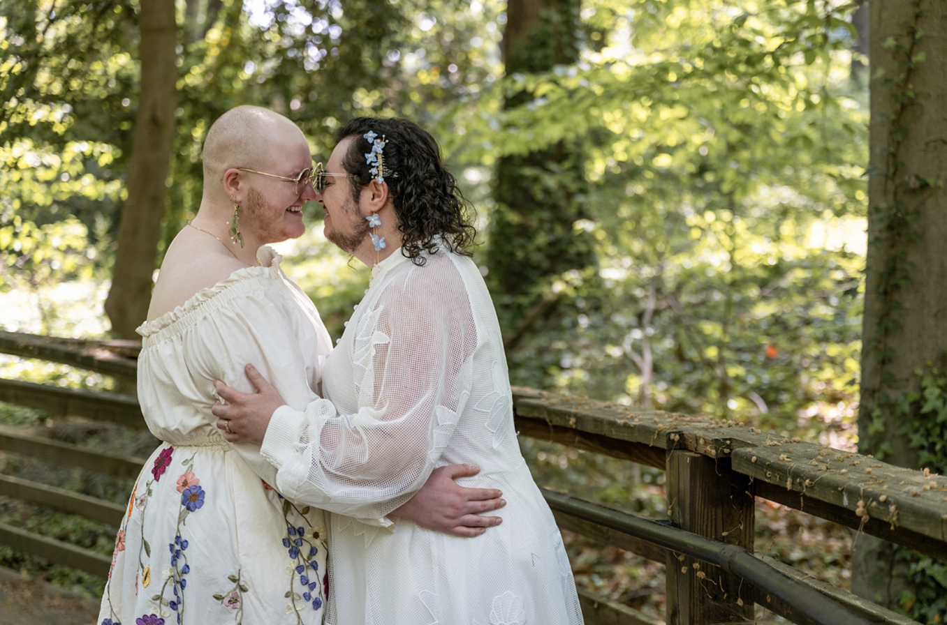 A couple rubs noses in the woods during golden hour