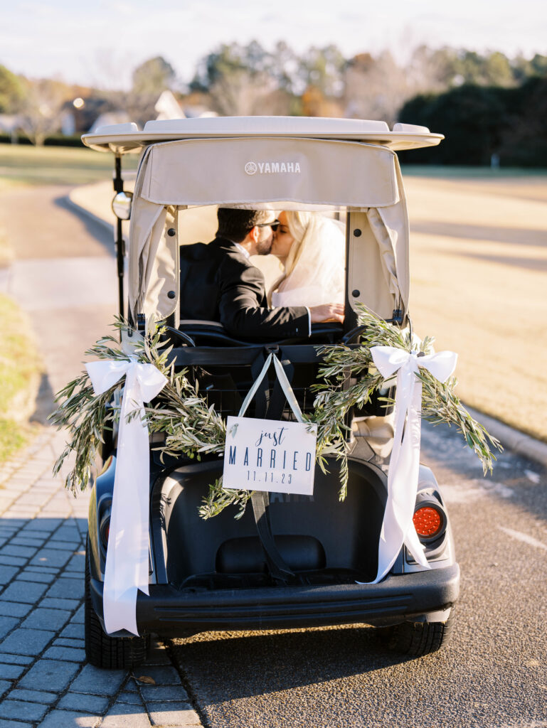 bride and groom in golf cart kissing