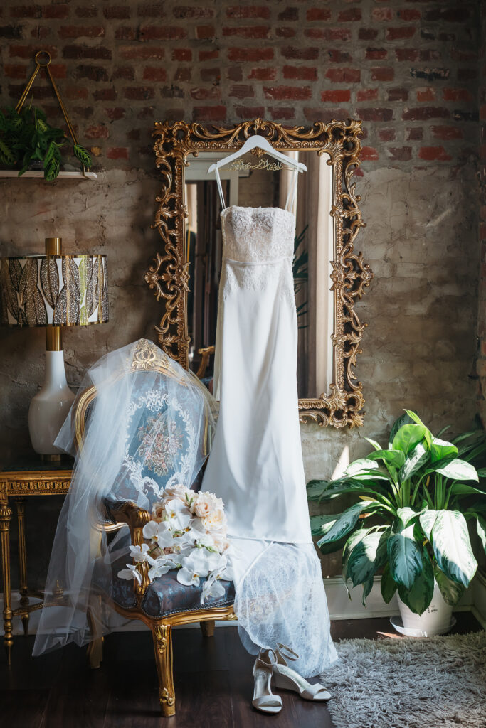 Gown hanging with veil and florals