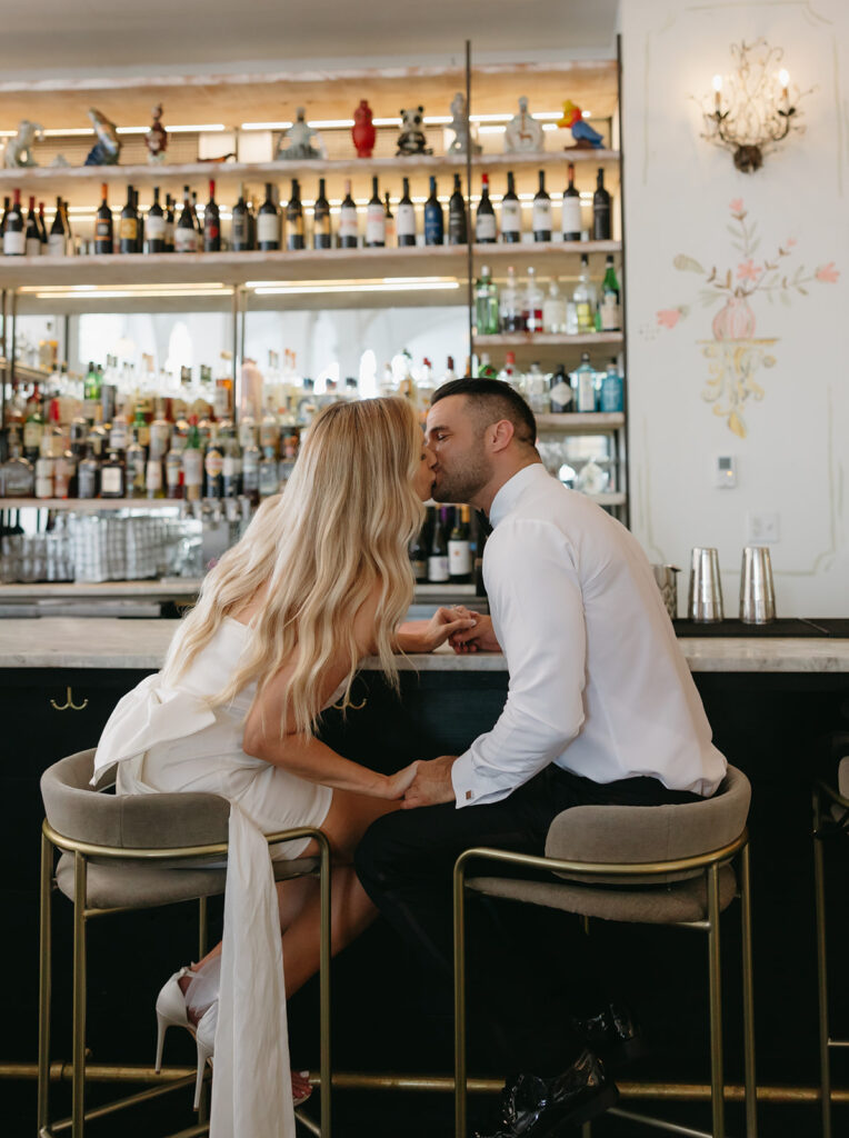 engaged couple kissing at hotel bar
