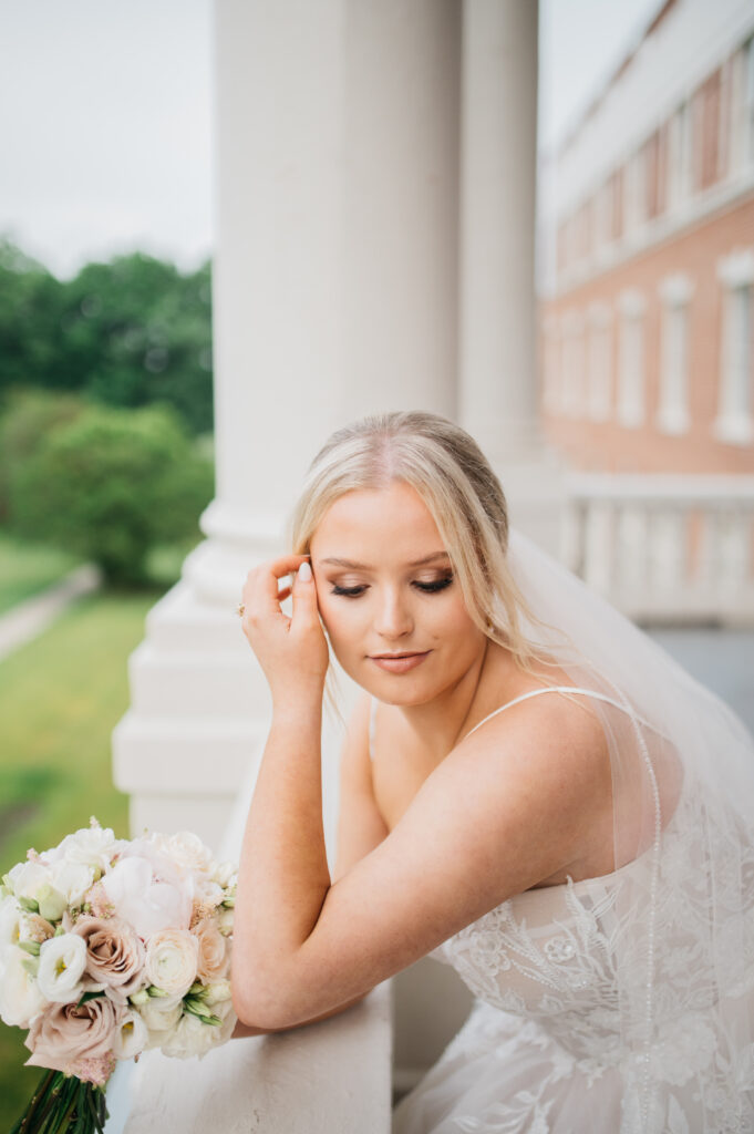 Bride leaning on balcony at the Inn at Blackstone