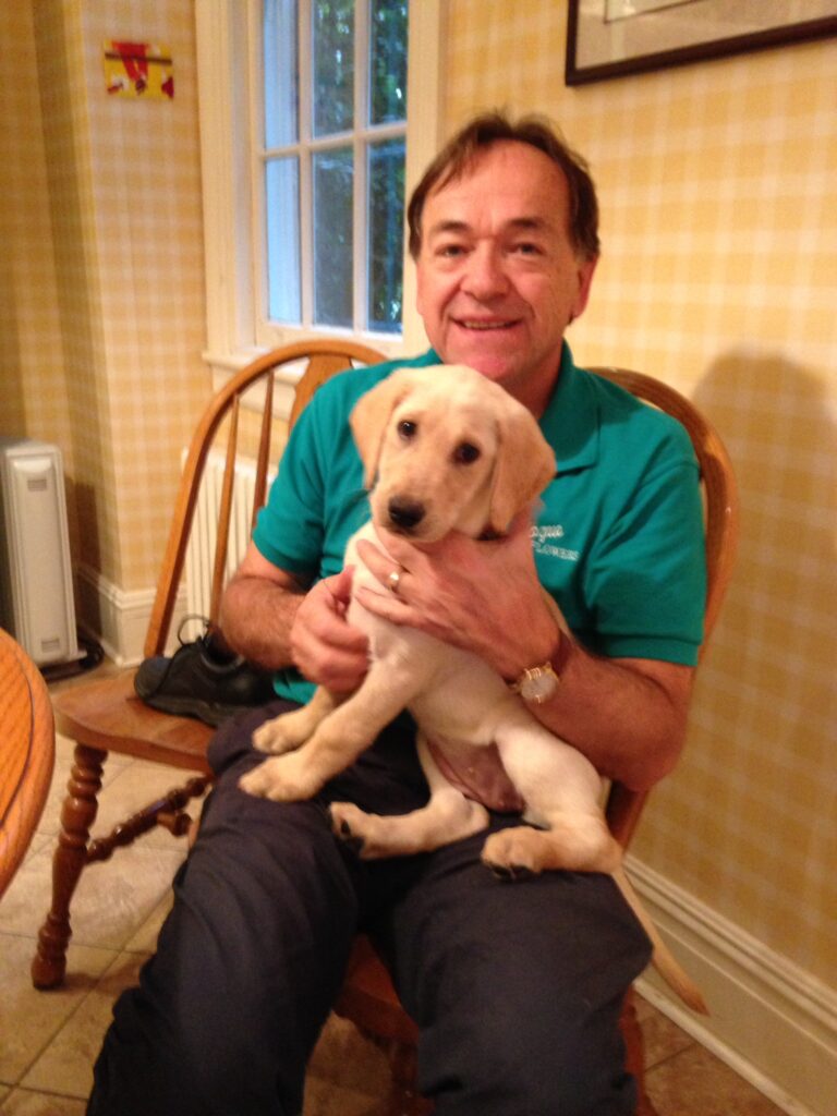 Man holding a yellow lab puppy